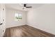 Bright bedroom features hardwood floors, a ceiling fan, and a window with a street view at 3707 E Amelia Ave, Phoenix, AZ 85018