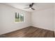 Bright bedroom features hardwood floors, a ceiling fan, and a window with a view of the backyard at 3707 E Amelia Ave, Phoenix, AZ 85018