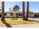 Front of home with beautiful landscaping, large palm trees, and carport at 3707 E Amelia Ave, Phoenix, AZ 85018