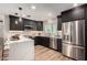 Modern kitchen featuring a tile backsplash, stainless steel appliances, and an island with a marble waterfall countertop at 3707 E Amelia Ave, Phoenix, AZ 85018