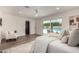 Bright main bedroom featuring modern fan, neutral walls, wood floors, decorative rug and a view of the pool at 3707 E Amelia Ave, Phoenix, AZ 85018