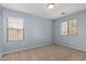 Carpeted bedroom has light blue walls and two large windows with window blinds at 3891 E Melrose St, Gilbert, AZ 85297