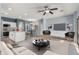 Open-concept living room boasts modern furnishings, a ceiling fan, and seamless flow to the kitchen and dining area at 3891 E Melrose St, Gilbert, AZ 85297