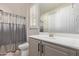 Bathroom featuring a white sink and cabinet, toilet, framed mirror and a shower with a silver curtain at 3942 N San Marin Dr, Florence, AZ 85132