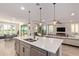 Spacious kitchen island with modern fixtures overlooks the living room and outdoor views through sliding glass doors at 3942 N San Marin Dr, Florence, AZ 85132