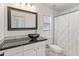 Stylish bathroom with a black vessel sink, dark countertop, and a framed mirror at 39526 N White Tail Ln, Anthem, AZ 85086