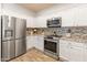 Updated kitchen with stainless steel appliances and white cabinetry at 39526 N White Tail Ln, Anthem, AZ 85086