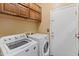 Laundry room with washer, dryer, upper cabinets and a utility door at 39526 N White Tail Ln, Anthem, AZ 85086