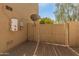 View of a side yard with tan stucco wall, gravel, and a gated access point at 39526 N White Tail Ln, Anthem, AZ 85086