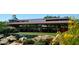 Daisy Mountain Railroad Depot framed by a pond with lush greenery at 39526 N White Tail Ln, Anthem, AZ 85086