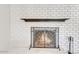 A white brick fireplace with a dark wood mantel and a decorative iron screen at 4201 W Brown St, Phoenix, AZ 85051