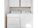 Well-lit laundry room featuring a white washer, dryer, and overhead cabinets for storage at 4201 W Brown St, Phoenix, AZ 85051