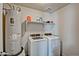 Bright laundry room featuring a washing machine, dryer, and water heater at 45322 W Sandhill Rd, Maricopa, AZ 85139