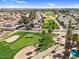 An aerial view of a well-maintained golf course lined with palm trees and residential homes under a clear blue sky at 4826 E Navajo Cir, Phoenix, AZ 85044