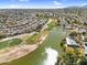 Panoramic aerial shot showcasing a serene lake, golf course and residential neighborhood under a bright blue sky with scattered clouds at 4826 E Navajo Cir, Phoenix, AZ 85044