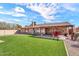 Expansive backyard featuring a covered patio, lush lawn, and low-maintenance desert landscaping at 4826 E Navajo Cir, Phoenix, AZ 85044