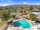 Aerial view of a pool surrounded by lounge chairs and lush trees, with mountains in the background at 4826 E Navajo Cir, Phoenix, AZ 85044