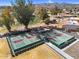 Aerial shot features well-maintained tennis and pickleball courts with green and red surfaces, ready for a match under the bright sun at 4826 E Navajo Cir, Phoenix, AZ 85044