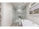 Bright bathroom featuring a walk-in shower with frameless glass door and soaking tub at 5726 E Woodridge Dr, Scottsdale, AZ 85254