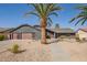 Inviting desert home with rock landscape, a stone walkway and mature palm trees creating great curb appeal at 5726 E Woodridge Dr, Scottsdale, AZ 85254