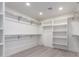 Bright walk-in closet featuring shelving, hanging rods and light wood-look floors at 5726 E Woodridge Dr, Scottsdale, AZ 85254