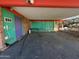 View of a covered carport area with a colorful door, next to a green slatted fence at 6528 N Hillside Dr, Paradise Valley, AZ 85253