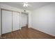 Bright bedroom featuring a closet, ceiling fan, and wood floors at 7335 W Mission Ln, Peoria, AZ 85345