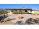 Charming single-story home with desert landscaping, covered front porch, and circular fire pit at 7335 W Mission Ln, Peoria, AZ 85345