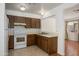 Functional kitchen featuring white appliances, wood cabinets, and an open view to the living area at 7335 W Mission Ln, Peoria, AZ 85345