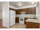 A cozy kitchen offering ample counter space, appliances and dark wood cabinetry at 7335 W Mission Ln, Peoria, AZ 85345