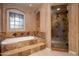 Elegant bathroom featuring a soaking tub, glass-enclosed shower, and designer tile work at 7705 E Doubletree Ranch Rd # 29, Scottsdale, AZ 85258