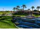 Scenic golf course view with a tiered waterfall, lush green grass, and palm trees against a clear blue sky at 7705 E Doubletree Ranch Rd # 29, Scottsdale, AZ 85258