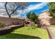 Outdoor space featuring a brick fireplace and a meticulously maintained lawn at 7910 W Spur Dr, Peoria, AZ 85383