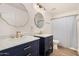 Modern bathroom boasts double sink vanity with stone countertop, gold hardware, and framed mirrors at 7910 W Spur Dr, Peoria, AZ 85383