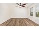 Well lit bedroom with wood floor, ceiling fan, and window with neighborhood view at 7910 W Spur Dr, Peoria, AZ 85383