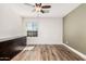 Bedroom with ceiling fan, wood floor, dresser, and bright natural light at 7910 W Spur Dr, Peoria, AZ 85383