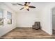 Spacious bedroom with natural light, chair, ceiling fan, and wood-look flooring at 7910 W Spur Dr, Peoria, AZ 85383