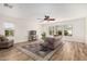 Bright living room featuring wood floors, area rug, sofa, and plentiful natural light at 7910 W Spur Dr, Peoria, AZ 85383