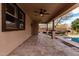 Covered patio view showcasing travertine flooring, dual ceiling fans, and outdoor backyard access at 7910 W Spur Dr, Peoria, AZ 85383