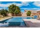 Inviting backyard pool surrounded by stone pavers and lush landscaping, perfect for relaxation and entertaining at 7910 W Spur Dr, Peoria, AZ 85383