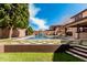 Backyard pool and lawn area featuring a tile walking path and partial view of the house at 7910 W Spur Dr, Peoria, AZ 85383