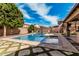 Outdoor swimming pool area with lounge chairs, tile deck, grassy landscaping, and a covered patio at 7910 W Spur Dr, Peoria, AZ 85383