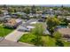 Aerial view of a home with an attached garage, lush green lawn, a mature shade tree, and neighborhood views at 829 E Desert Park Ln, Phoenix, AZ 85020