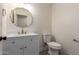 Charming powder room featuring a patterned floor, white vanity, and gold fixtures at 829 E Desert Park Ln, Phoenix, AZ 85020