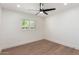 Bright bedroom features hardwood floors, fan, and a window with plantation shutters at 829 E Desert Park Ln, Phoenix, AZ 85020