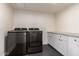 Spacious laundry room with modern washer, dryer, and white cabinetry at 829 E Desert Park Ln, Phoenix, AZ 85020