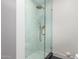 Glass enclosed shower with blue tile and gold fixtures at 829 E Desert Park Ln, Phoenix, AZ 85020