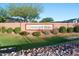 Well-manicured community sign for Crescent Run features seasonal flowers, green grass, and a rock-lined berm at 8500 E Southern Ave # 463, Mesa, AZ 85209