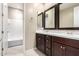 Bathroom with double sink vanity, dark cabinets, and combination shower-tub at 9382 W Louise Dr, Peoria, AZ 85383