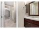 Bathroom vanity with dark cabinets, marble countertop, and framed mirrors at 9382 W Louise Dr, Peoria, AZ 85383